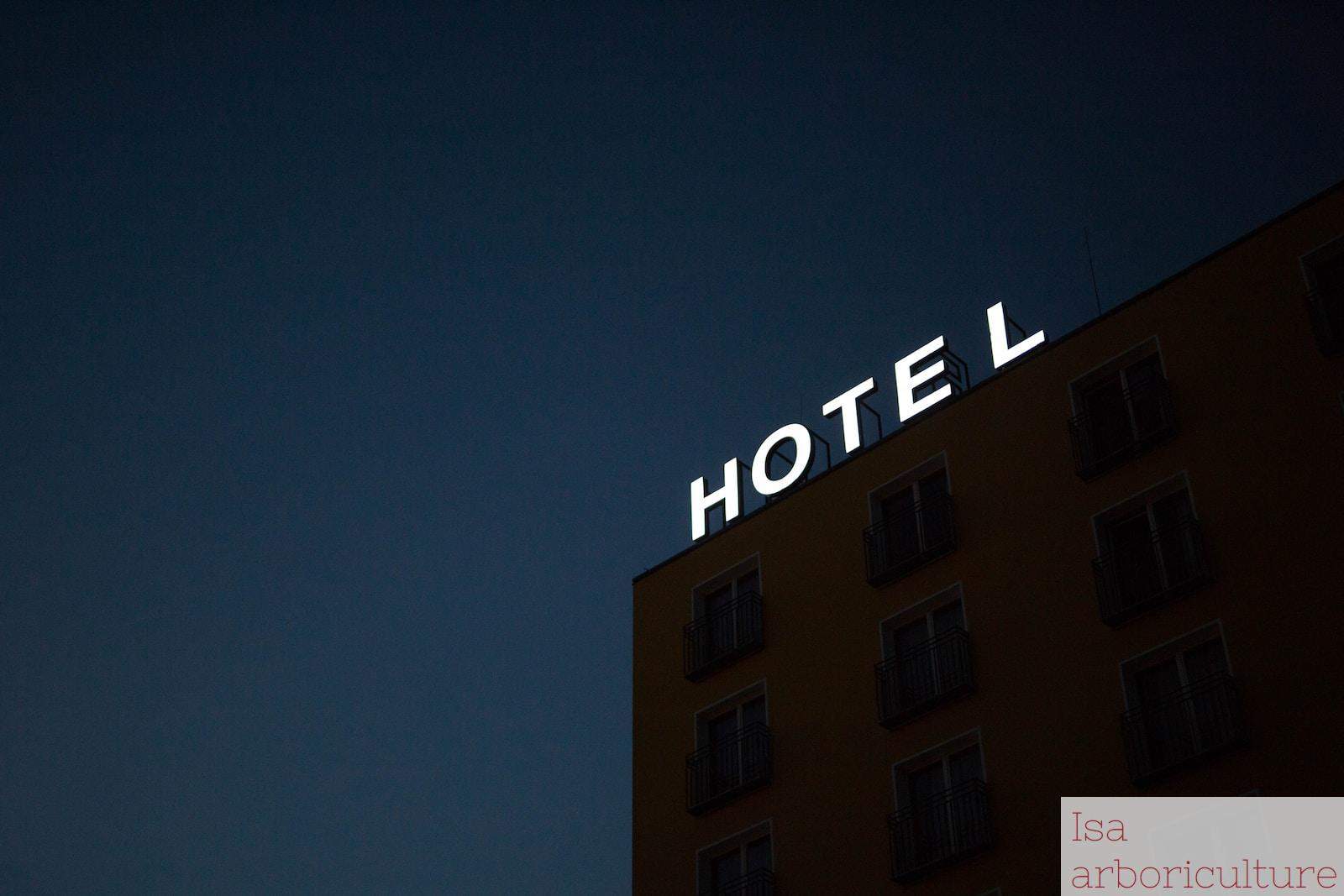 low-angle photo of Hotel lighted signage on top of brown building during nighttime